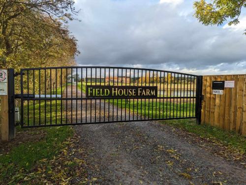 a gate with a field house farm sign on it at The Dairy, quiet countryside location near York in Wilberfoss