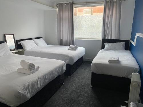 a room with three beds with towels on them at The Regency Hotel in Blackpool