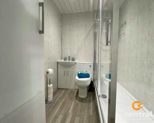 a white bathroom with a toilet and a shower at 1 Bedroom Apartment by Central Serviced Apartments - Modern - FREE Street Parking - Close to University of Dundee - Weekly-Monthly Stay Offers - Wi-Fi - Cosy Little Apartment in Dundee