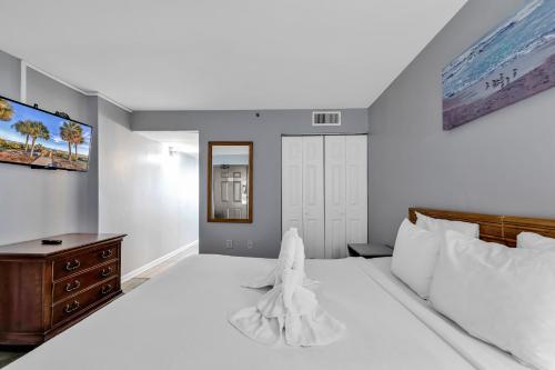 een slaapkamer met een groot wit bed en een dressoir bij Oceanfront Private Balcony Condo at Meridian Plaza in Myrtle Beach