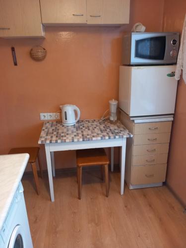 Il comprend une petite cuisine avec une table, un four micro-ondes et un réfrigérateur. dans l'établissement Sunflower, à Jurmala