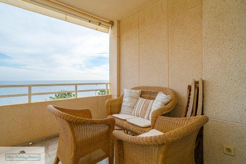a balcony with wicker chairs and a view of the ocean at Cabo Mar Apartment sea view/pool in El Campello