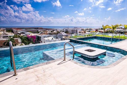 a swimming pool on the roof of a building at Ocean view Studio, Rooftop Pool, steps from beach Hyatt in Playa del Carmen