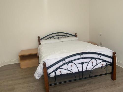 een slaapkamer met een bed met een metalen bedframe bij EAST LONDON En-Suite Contact US FOR GROUP BOOKING & LONG TERM BOOKIN in Ilford