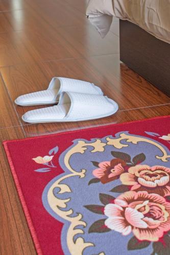 a pair of white shoes and a rug on a floor at Hideaway Guest House And Bar in Pattaya Central