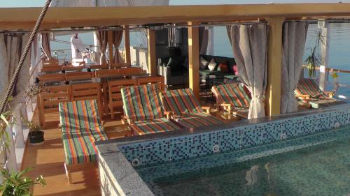 a balcony with chairs and a swimming pool on a ship at Ben's Dahabeya in Aswan