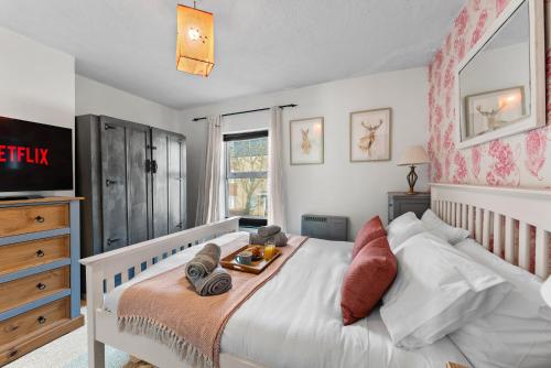 ein Schlafzimmer mit einem Bett, auf dem ein Tablett mit Essen steht in der Unterkunft 139 I Abbey House I Characterful & Peaceful 1BR House w Garden, Rooftop Balcony, Fully Equipped Kitchen and Dedicated Workspace in Bury Saint Edmunds