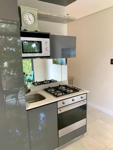 a kitchen with a stove and a clock on the wall at OAM The Paramount Rosebank Luxury One-Bedroom in Johannesburg