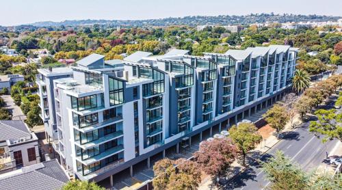 an aerial view of a building with blue windows at OAM The Paramount Rosebank Luxury One-Bedroom in Johannesburg