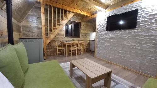 a living room with a couch and a tv on a wall at BRVNARE DJOKIĆ in Ðokici
