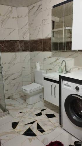 a bathroom with a toilet and a washing machine at HAPPY HOUSE 1 Pamukkale in Pamukkale