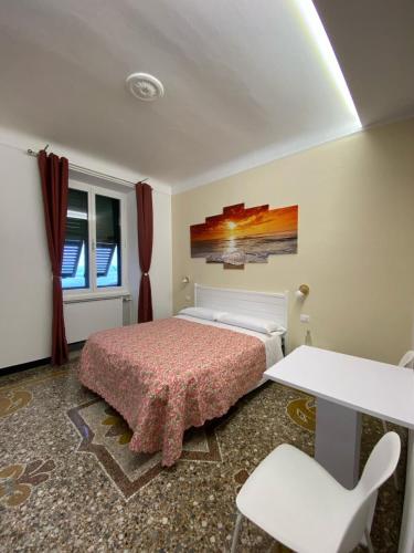 Un dormitorio con una cama y una mesa y sillas. en AffittaCamere Columbus, en Camogli