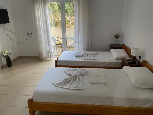 - 2 lits dans une chambre d'hôtel avec des serviettes dans l'établissement T. Bello Apartments, à Saranda