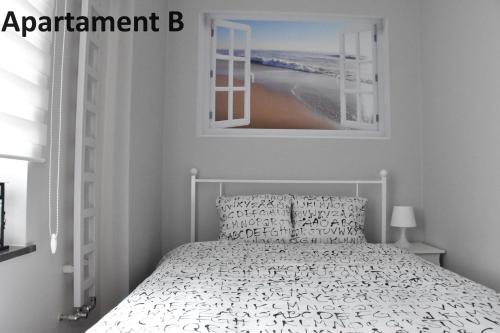 ein Schlafzimmer mit einem Bett und einem Bild von einem Strand in der Unterkunft Apartament za 400m Plaża Sopot in Sopot