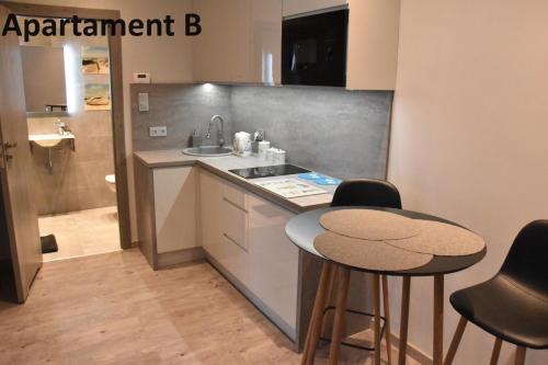 a kitchen with a sink and two bar stools at Apartament za 400m Plaża Sopot in Sopot