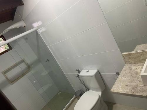 een witte badkamer met een toilet en een douche bij Casa Ampla em Guarajuba in Camassari