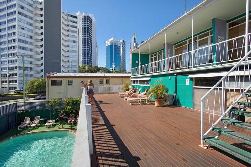 a building with a deck with a swimming pool at Backpackers In Paradise 18-35 Hostel in Gold Coast