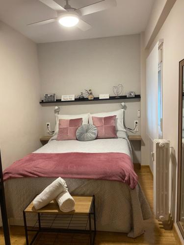 um quarto com uma cama grande e almofadas cor-de-rosa em Apto en el Centro La Casita de Gaos Parking Gratuito em Granada