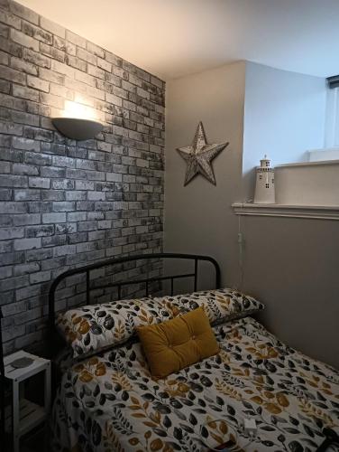1 dormitorio con cama y pared de ladrillo en Bijou Apartment en Berwick-Upon-Tweed