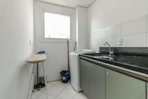 eine weiße Küche mit Spüle und Fenster in der Unterkunft Apartamento 2 dormitorios Novo Hamburgo Espaço Namibe in Novo Hamburgo