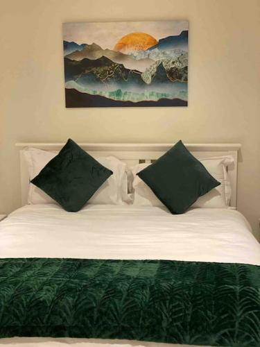 a bed with green and white sheets and pillows at Modern family home in Castleisland