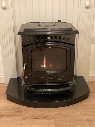 a black stove with a fire in a room at Modern family home in Castleisland