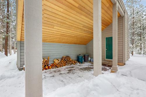 a building with a pile of wood in the snow at Golf Home 155 in Black Butte Ranch