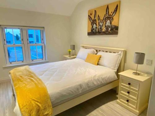 sypialnia z białym łóżkiem i oknem w obiekcie Modern family home w mieście Castleisland