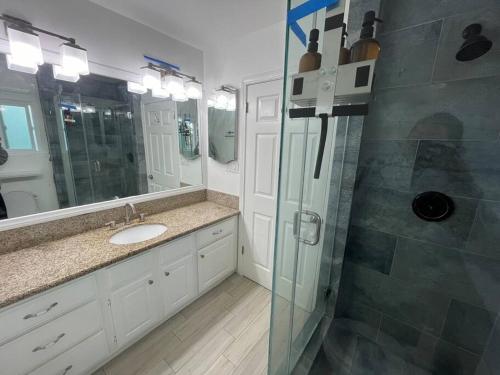 a bathroom with a shower and a sink and a mirror at Downtown Manhattan Beach Walk Street in Manhattan Beach