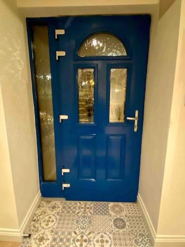 a blue door in a room with a tile floor at Modern family home in Castleisland