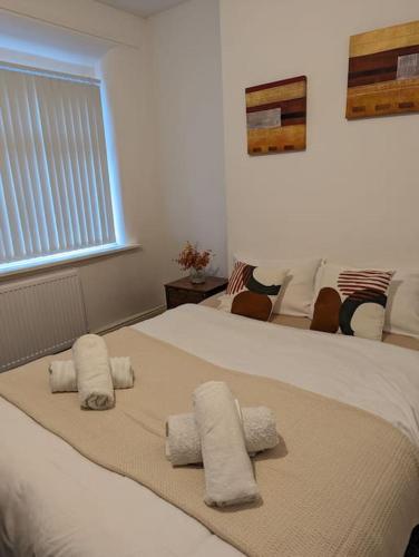 a bedroom with two white towels on a bed at 3-bed Home For Football Fans in Liverpool