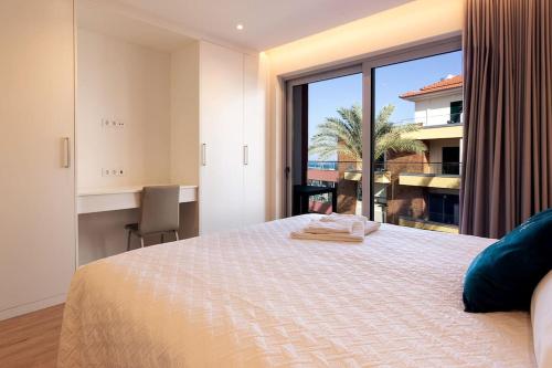 a bedroom with a large bed and a large window at Luxury and modern apartment in Porto Moniz center in Porto Moniz
