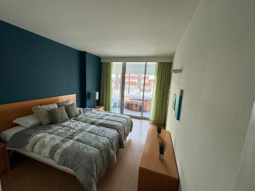 Schlafzimmer mit einem Bett mit blauer Wand in der Unterkunft Newly refurbished 2 bed appt Vilamoura in Vilamoura