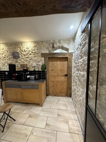 une cuisine avec une porte en bois et un sol carrelé dans l'établissement Appartement privé avec piscine vue exceptionnelle sur l'eau, à Groslée