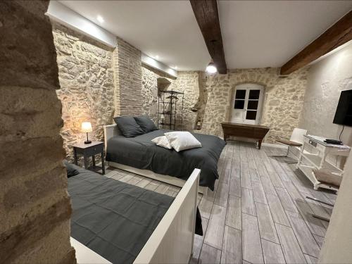 une chambre avec un lit et un mur en pierre dans l'établissement Appartement privé avec piscine vue exceptionnelle sur l'eau, à Groslée