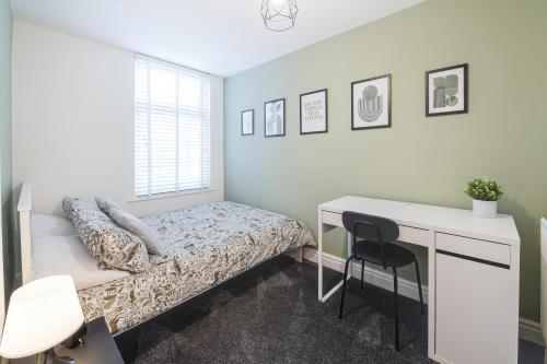 1 dormitorio con cama y escritorio en Poppy's Project - July Road, en Liverpool