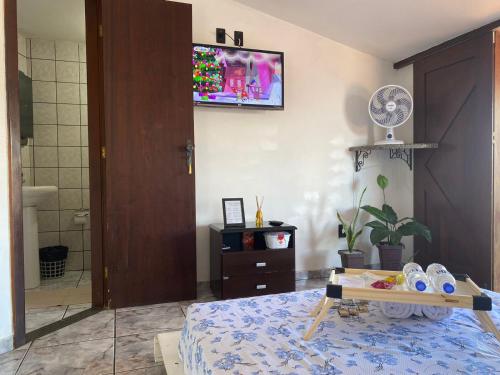 1 dormitorio con 1 cama y TV en la pared en Apartamento Sol Nascente no centro da cidade en Cruz das Almas