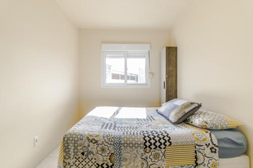 1 dormitorio con cama y ventana en Apartamento 2 dormitorios Novo Hamburgo Espaço Namibe en Novo Hamburgo