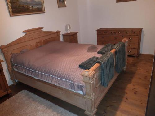 a bedroom with a wooden bed and a dresser at Rustico di Angelo in Prem