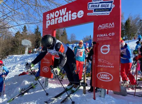 a man on skis standing next to a sign at Apartmán Diana in Oščadnica