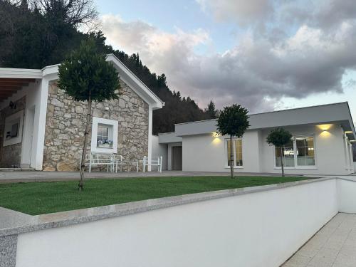 a white house with a lawn in front of it at Villa Aria in Mostar