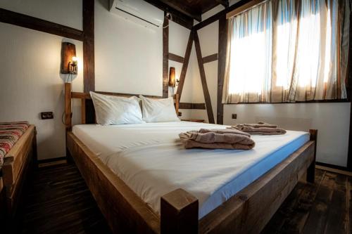 um quarto com uma cama grande e toalhas em Vila Chiflik Troyan em Troyan
