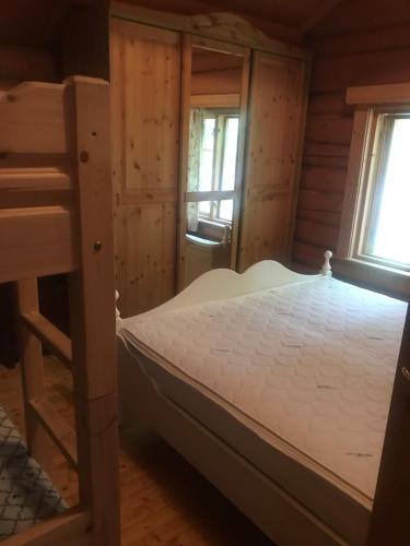 a bedroom with a bunk bed and two windows at Rønlund Hyttepark in Ron