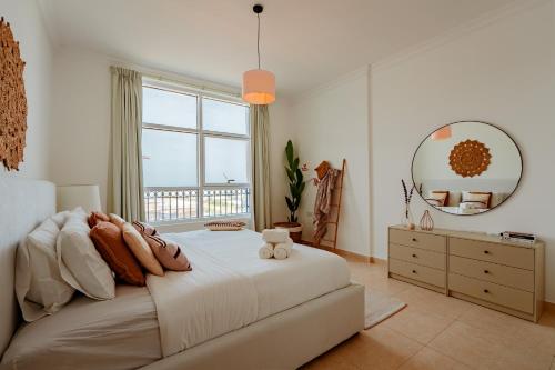 een slaapkamer met een groot bed en een spiegel bij Voyage One Bedroom In Ansam in Abu Dhabi