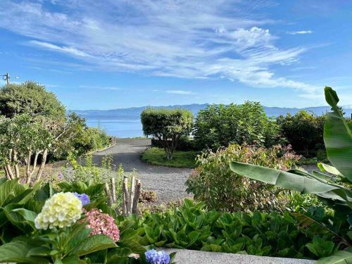 a garden with flowers and trees and a pathway at Casa Pequena da Terra Alta in Santo Amaro