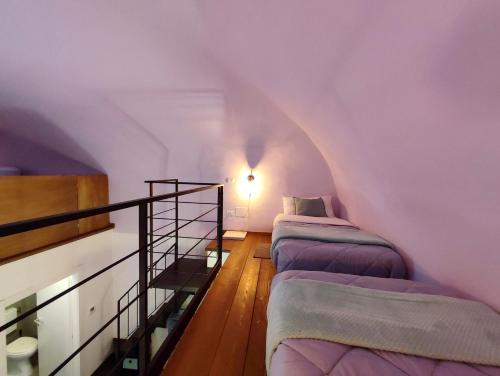 a attic room with three beds and a staircase at Loft Centro Storico Accesso Senza Scale "Carvajal Rooms " Due Passi dal Duomo, Netflix Incluso in Orvieto