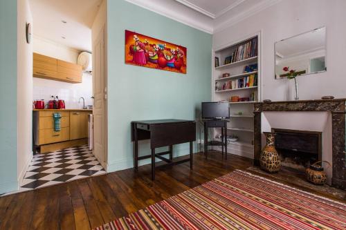 un salon avec une table et une cheminée dans l'établissement Studio I love Montmartre, à Paris