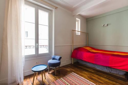 une chambre avec un lit, une chaise et une fenêtre dans l'établissement Studio I love Montmartre, à Paris