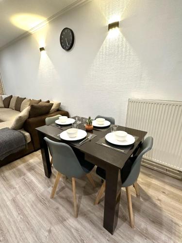 - une table à manger noire avec des chaises et un canapé dans l'établissement Une belle maison avec 2 chambre, à Croix