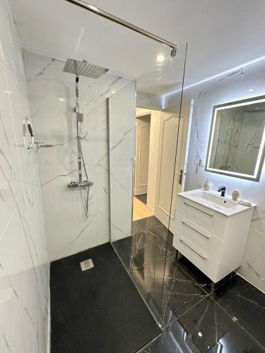 une salle de bain blanche avec un lavabo et une douche dans l'établissement Une belle maison avec 2 chambre, à Croix